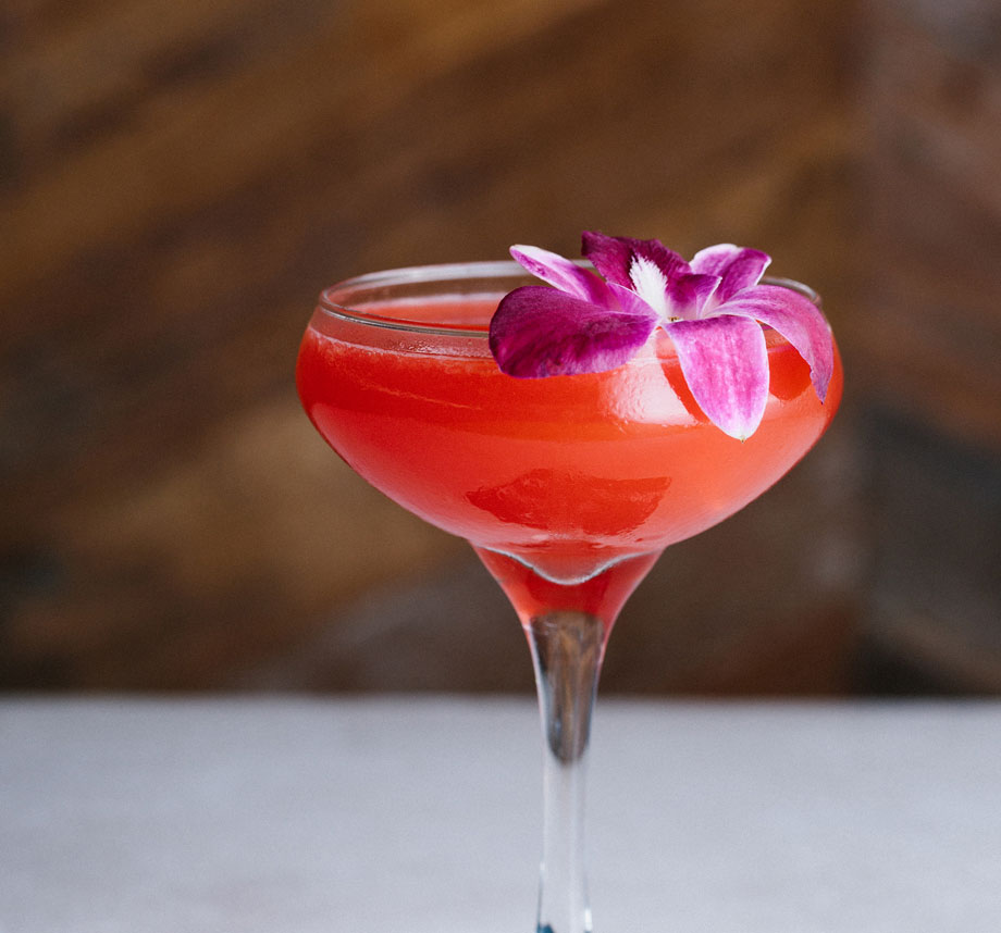 pink cocktail garnished with flower